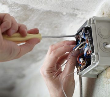 Worker installing the plastic electrical box on the wall